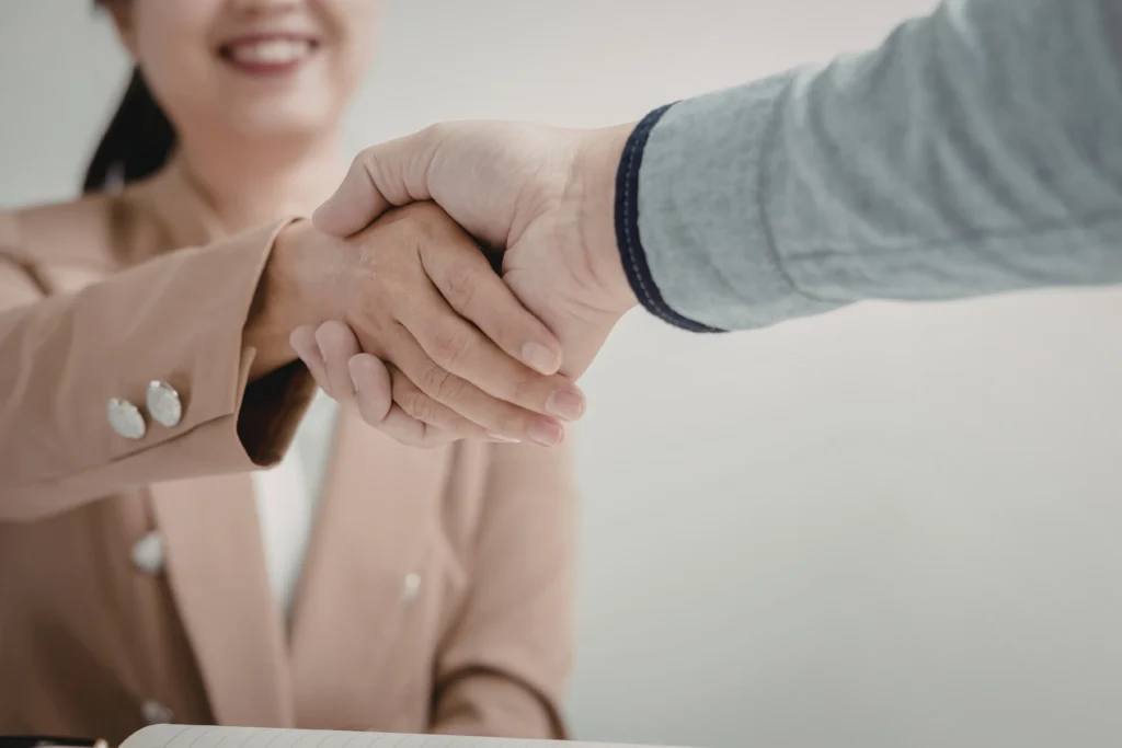 Medical billing company owner shaking hands with a healthcare provider after signing a new client agreement