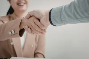 Medical billing company owner shaking hands with a healthcare provider after signing a new client agreement