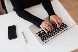 Woman working from home on a laptop building a remote side hustle