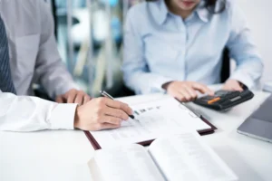 Business owner and advisor reviewing loan paperwork and financial projections for a medical billing startup