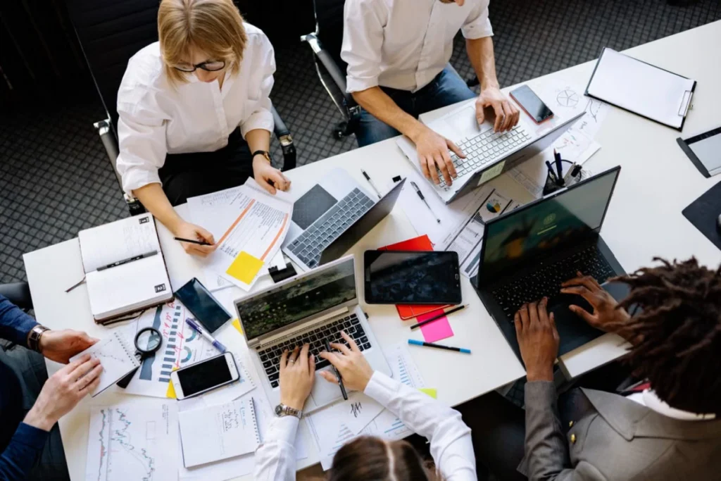 Billing professionals studying exam materials and claim reports around a shared desk