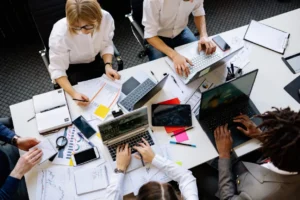 Billing professionals studying exam materials and claim reports around a shared desk